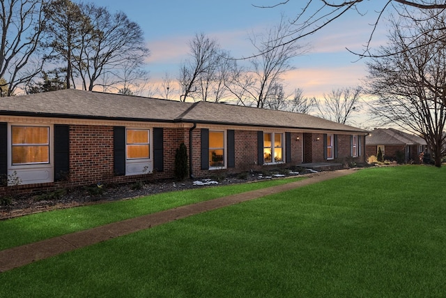 ranch-style home with a yard