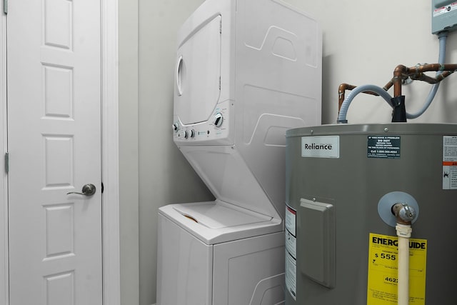 clothes washing area featuring water heater and stacked washer / drying machine