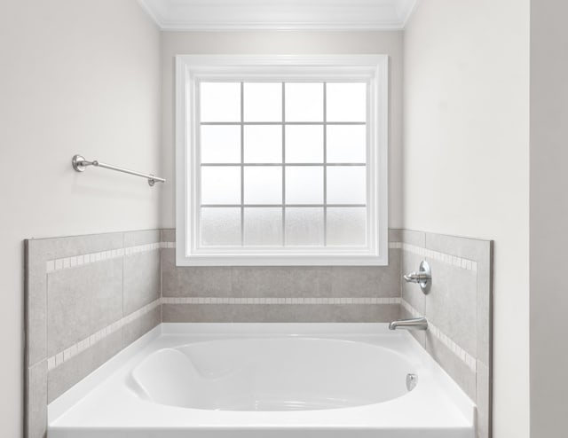 bathroom with a bath and crown molding