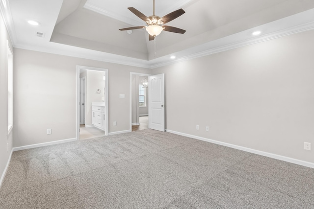 unfurnished bedroom featuring connected bathroom, light carpet, a raised ceiling, ceiling fan, and crown molding