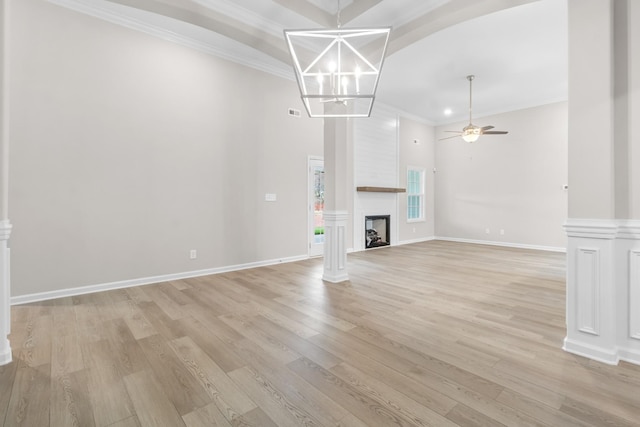 unfurnished living room with a large fireplace, ceiling fan with notable chandelier, light hardwood / wood-style flooring, and ornamental molding