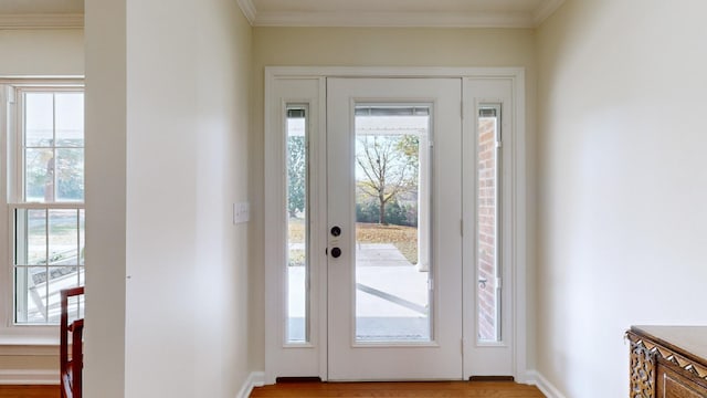 entryway featuring crown molding, plenty of natural light, and light wood-type flooring