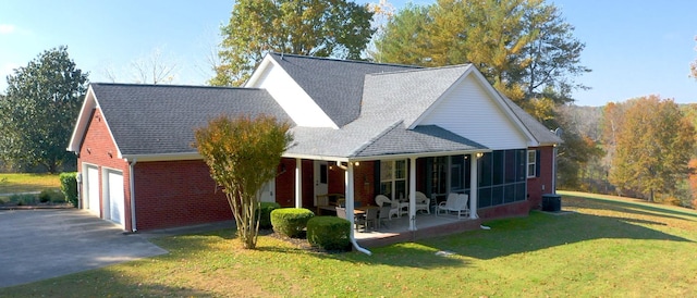 view of front of property featuring a porch, a garage, central AC unit, a sunroom, and a front lawn