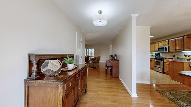 hall featuring ornamental molding and light hardwood / wood-style floors