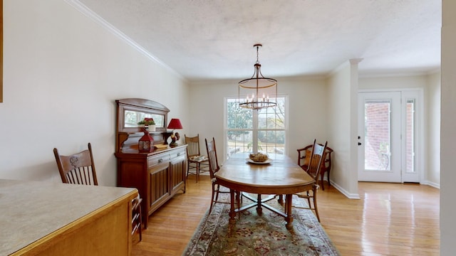 dining area with crown molding, a textured ceiling, light hardwood / wood-style flooring, and a notable chandelier