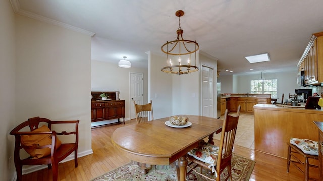 dining area with an inviting chandelier, sink, crown molding, and light hardwood / wood-style floors