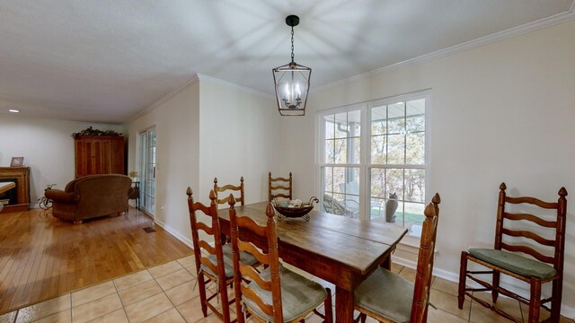 dining room with crown molding, a notable chandelier, and light tile patterned floors