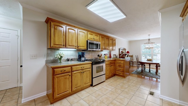 kitchen with appliances with stainless steel finishes, pendant lighting, backsplash, ornamental molding, and light tile patterned floors