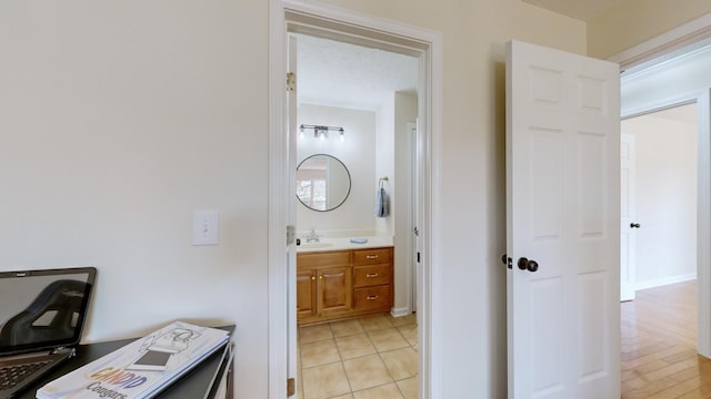 bathroom featuring tile patterned flooring, vanity, and a textured ceiling