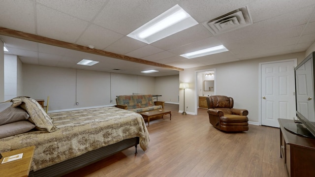 bedroom with wood-type flooring and a paneled ceiling