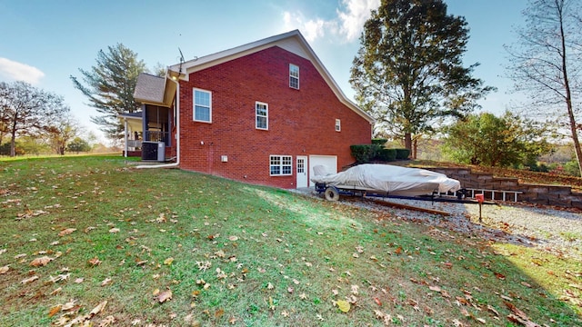 view of side of property featuring central AC, a sunroom, and a lawn