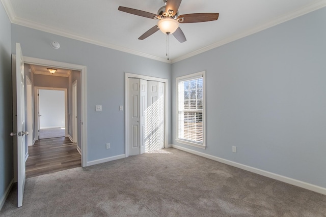 unfurnished bedroom with ceiling fan, a closet, carpet, and crown molding