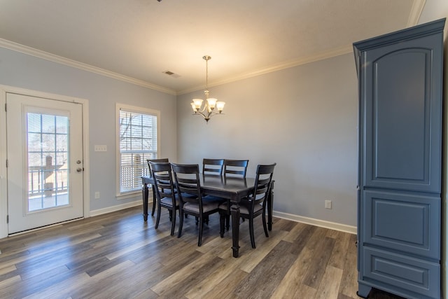 dining room featuring dark wood-type flooring, crown molding, and a notable chandelier