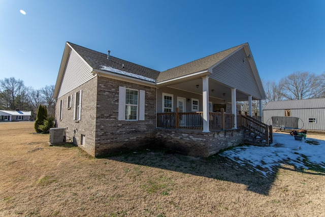 exterior space with cooling unit, a porch, and a front yard