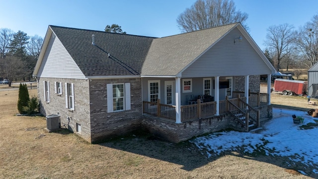 view of front of house featuring covered porch, a front lawn, and central air condition unit