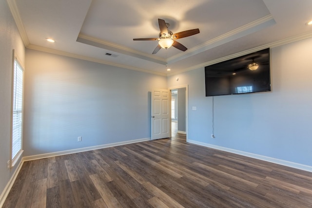 spare room with dark wood-type flooring, ornamental molding, a wealth of natural light, and a raised ceiling