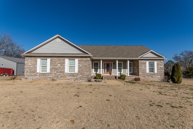 single story home featuring covered porch and a front lawn