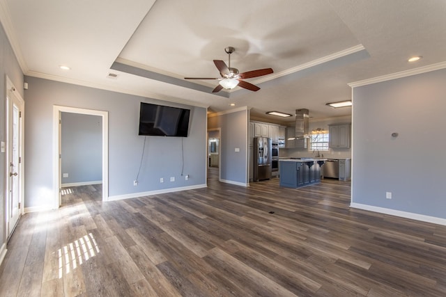 unfurnished living room with crown molding and a raised ceiling