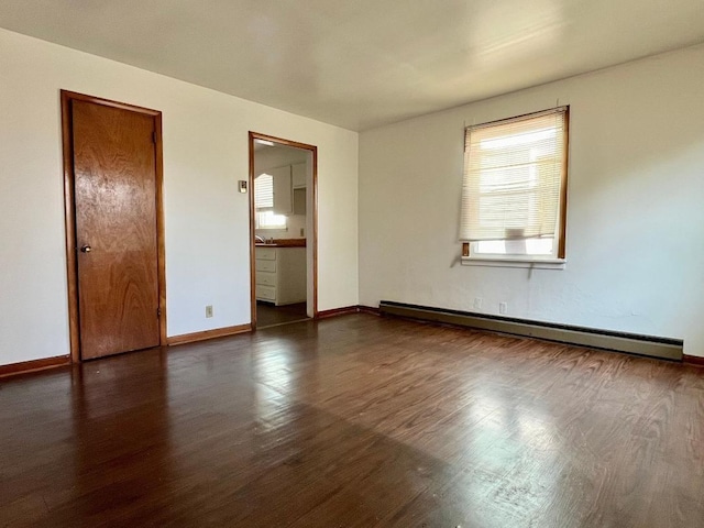 spare room featuring dark wood-type flooring and baseboard heating