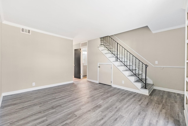 unfurnished living room featuring crown molding and hardwood / wood-style flooring