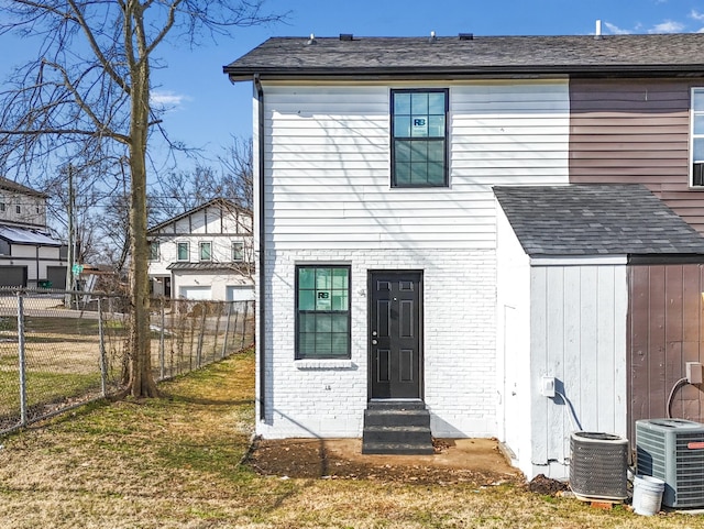 rear view of house with a lawn and central air condition unit