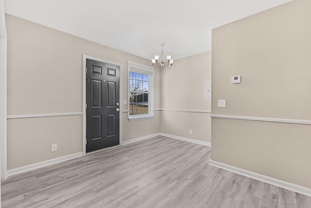 entrance foyer featuring an inviting chandelier and light hardwood / wood-style floors