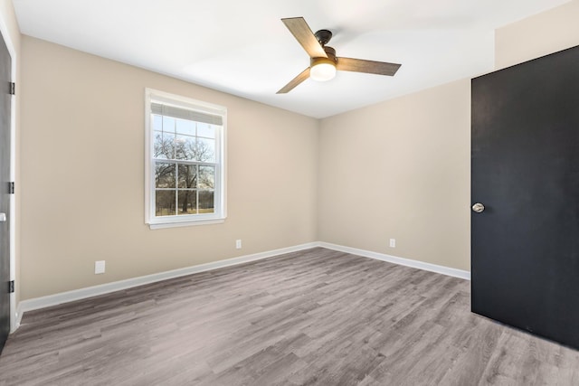 empty room with ceiling fan and light hardwood / wood-style flooring