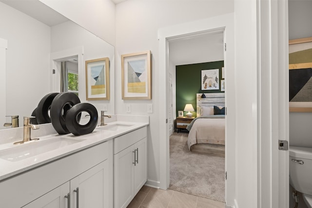 bathroom with toilet, vanity, and tile patterned flooring