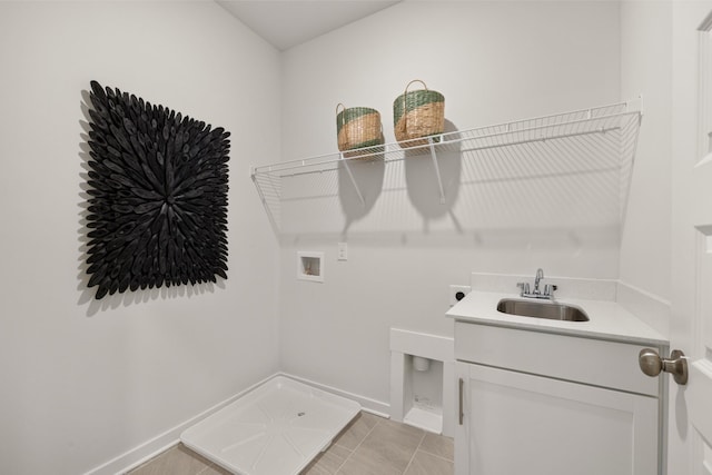 clothes washing area with hookup for an electric dryer, light tile patterned flooring, hookup for a washing machine, cabinets, and sink