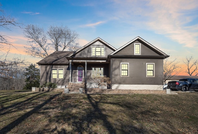 view of front of property featuring covered porch and a yard