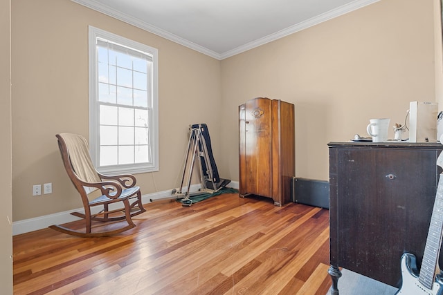 living area with crown molding and hardwood / wood-style flooring