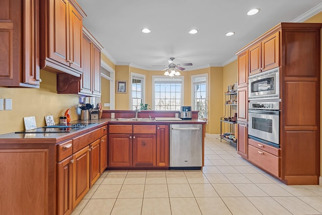 kitchen featuring ceiling fan, appliances with stainless steel finishes, crown molding, and kitchen peninsula