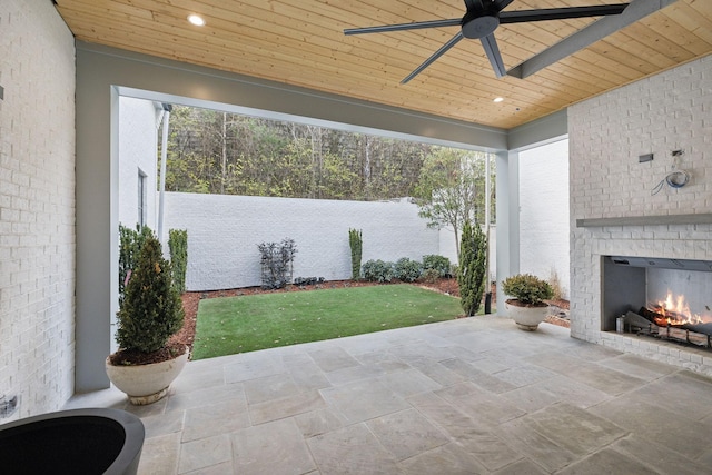 view of patio with an outdoor brick fireplace and ceiling fan