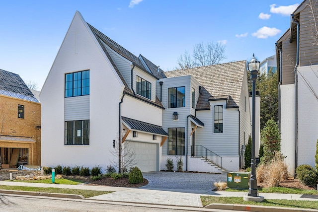 view of front facade with an attached garage, decorative driveway, and brick siding