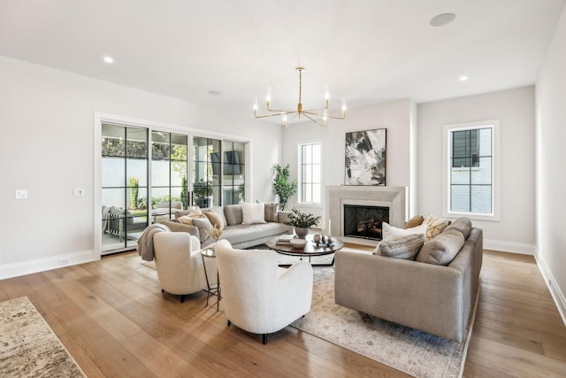 living room with a chandelier, recessed lighting, wood-type flooring, and a fireplace