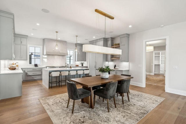 dining room featuring baseboards, light wood-type flooring, and recessed lighting