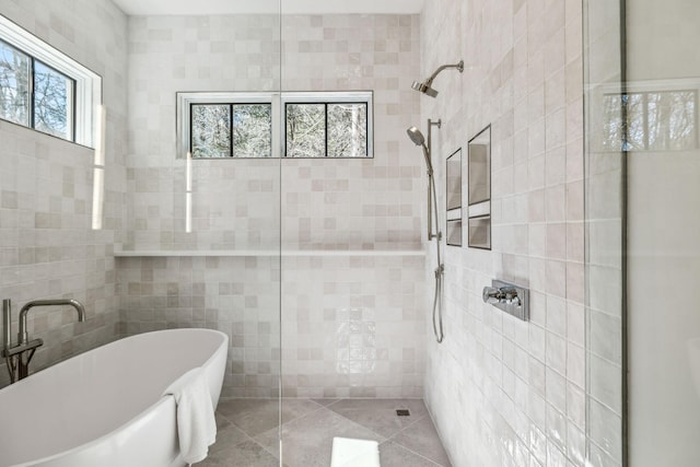 bathroom featuring a tile shower, tile walls, and a freestanding bath