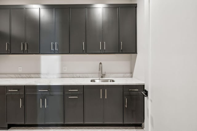 kitchen with light stone counters and a sink