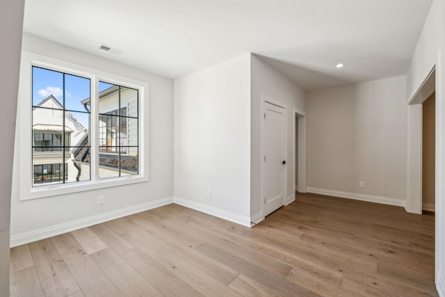 unfurnished room with recessed lighting, baseboards, visible vents, and light wood finished floors