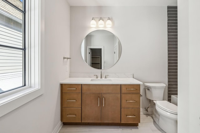 bathroom with toilet, baseboards, and vanity