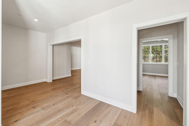 spare room with light wood-style floors, recessed lighting, and baseboards