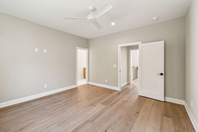 unfurnished room with light wood-style floors, baseboards, and a ceiling fan