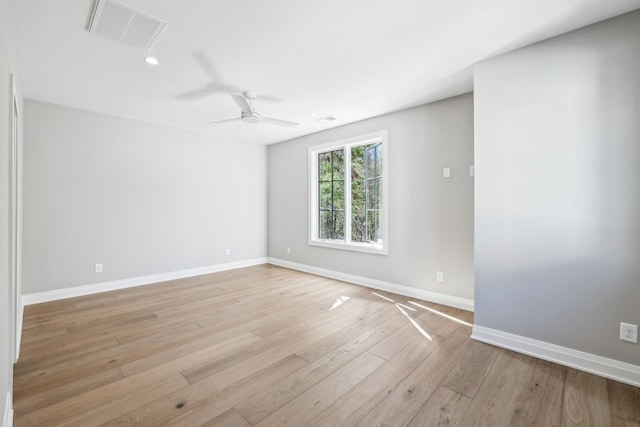 unfurnished room with a ceiling fan, light wood-type flooring, visible vents, and baseboards