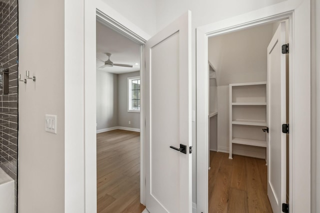 hall featuring baseboards and wood finished floors