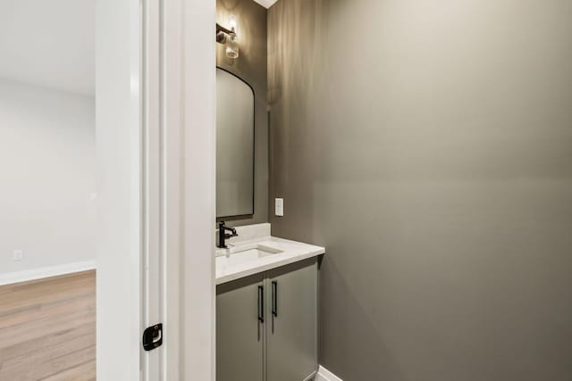 bathroom with baseboards, wood finished floors, and vanity