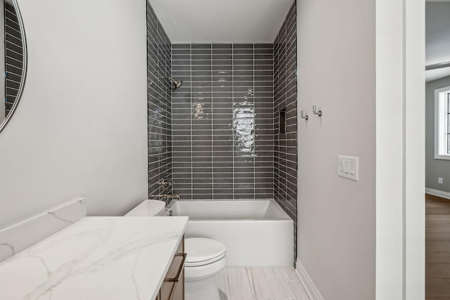 bathroom with baseboards, toilet, wood finished floors, vanity, and shower / bathing tub combination