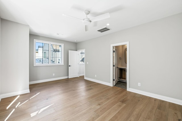 unfurnished bedroom with a ceiling fan, visible vents, baseboards, light wood finished floors, and ensuite bath