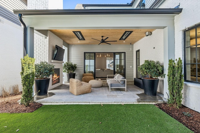 view of patio / terrace featuring an outdoor living space with a fireplace and ceiling fan