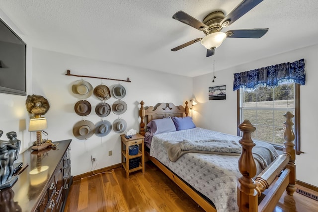 bedroom featuring hardwood / wood-style flooring, a textured ceiling, and ceiling fan