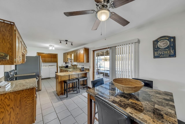 dining room with sink, ceiling fan, washer and clothes dryer, and light tile patterned floors